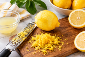 Fresh lemons being zested for homemade lemon ice cream recipe with lemon zest and juice preparation