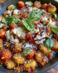 Smashed Gnocchi Skillet with crispy golden gnocchi, cherry tomatoes, creamy burrata, Parmesan, basil, and balsamic glaze